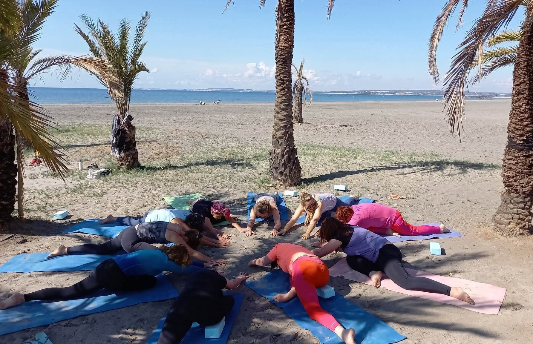 Práctica grupal de yoga junto al mar